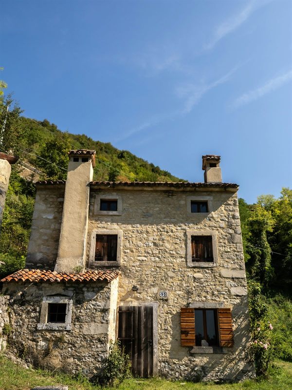 Une maison en pierre adossée à la colline